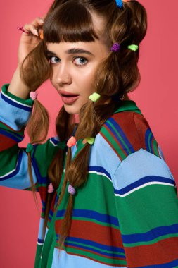 Şık bir kadın kendine güvenerek poz veriyor, renkli kıyafetlerini ve neşeli saç aksesuarlarını vurguluyor..