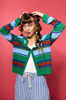 Genç bir kadın renkli aksesuarlarla süslü bir kıyafet giyerken neşeli bir sürpriz yapar..