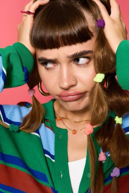 Şık bir kadın neşeyle saçını geriye doğru çekiyor, hayal kırıklığı belirtileri gösteriyor..