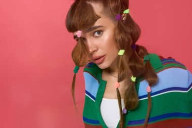 Genç bir kadın rengarenk kıyafetler ve neşeli saç aksesuarlarıyla tarzını sergiliyor..