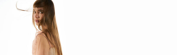 Молодая красивая женщина в модном наряде разворачивается, ее длинные волосы танцуют в воздухе.