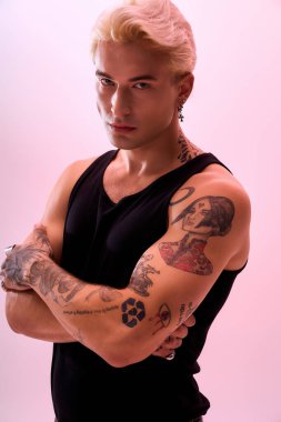 Kendine güvenen genç adam yumuşak bir zemine karşı dövmeler ve eşsiz bir stil sergiliyor..