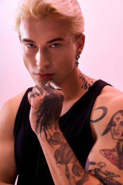 Yakışıklı genç adam moda anlayışını ve çarpıcı dövmelerini canlı bir ortamda sergiliyor..