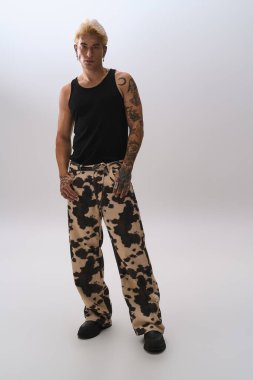 Yakışıklı genç adam, temiz bir arkaplanda şık bir şekilde poz veriyor..