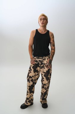 Yakışıklı genç adam kendine güvenerek poz veriyor. Stüdyoda havalı bir kıyafet sergiliyor..