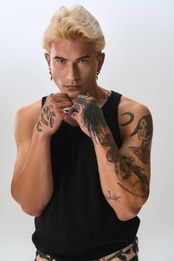 Yakışıklı genç adam moda anlayışını dövmelerle sergiliyor, içeride cesur bir poz veriyor..