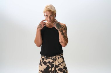 Yakışıklı genç adam moda anlayışını sergilerken kendine güvenen bir duruş sergiliyor..