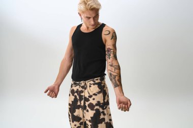 Yakışıklı genç adam, kendine has tarzını ve dövmelerini parlak bir ışıkla vurguluyor..