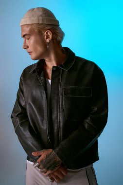 Yakışıklı genç adam kendine güveniyor, şık deri ceketini ve eşsiz aksesuarlarını sergiliyor..