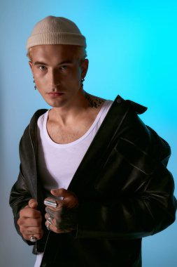 Genç adam kendine güveni tam bir şekilde şık giyiniyor, canlı bir arkaplanda cazibe yayıyor..