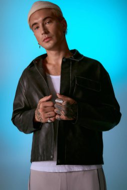 Yakışıklı genç adam kendine güvenerek şık bir deri ceketle poz veriyor, benzersiz tarzını gösteriyor..