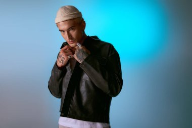 Kendine güvenen genç bir adam modaya uygun bir şekilde poz veriyor. Renkli bir geçmişe karşı cazibe ve tarz yayıyor..