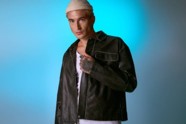 Kendine güvenen genç adam, canlı bir arkaplan karşısında modern modayı sergiliyor..