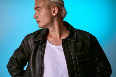 Yakışıklı genç adam eşsiz bir ışıkla şık bir poz verirken moda anlayışını sergiliyor..