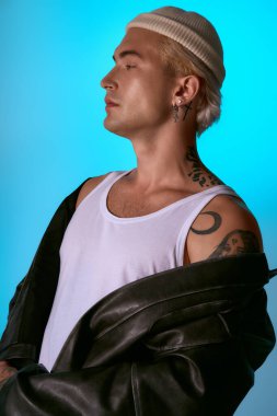 Genç adam, parlak bir arka plana karşı havalı bir havayla şık bir şekilde poz veriyor..