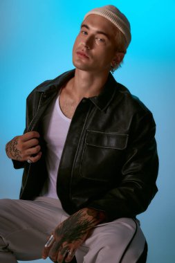 Yakışıklı genç adam kendine güvenerek modaya uygun bir şekilde poz veriyor, canlı bir geçmişi var, karizma yayıyor..