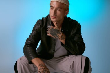 Moda kıyafetleri içindeki yakışıklı genç adam kendine güvenen pozunu verirken stilini ve karizmasını sergiliyor..