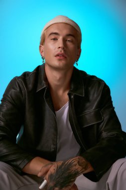 Genç bir adam modaya uygun bir kıyafetle, modern stil öğeleri sergileyerek güven yayar..