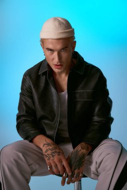 Yakışıklı bir genç, kendine güvenini sergilerken aynı zamanda rahat bir duruş sergiliyor..