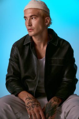 Yakışıklı genç adam dikkat çekici mavi arkaplanlı modaya uygun kıyafetler giyiyor..