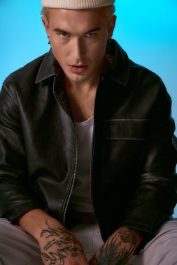 Zarif ceketli şık genç adam canlı bir arkaplana karşı güvenle poz veriyor..