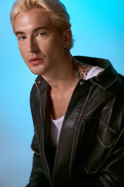 Yakışıklı genç adam dikkat çekici mavi bir geçmişi olan, kendine güveni olan modaya uygun bir kıyafet modelliyor..