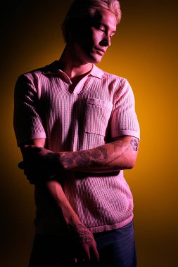 Yakışıklı genç adam sanatsal pozlar verirken modern moda sergiliyor..