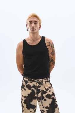 Genç adam kendine güveni tam bir şekilde duruyor, kendine has tarzını ve tavrını sergiliyor..