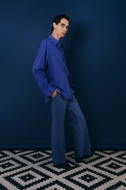 Modaya uygun bir adam şık bir ortamda şık mavi elbisesini sergiliyor..