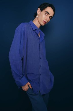 Şık bir adam eşsiz bir moda anlayışı sergiliyor. Gösterişli bir ortamda çarpıcı bir mavi gömleği var..