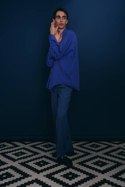 Modayı takip eden genç adam moda anlayışını sanatsal döşemeleri olan şık bir mekanda sergiliyor..