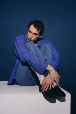 Yakışıklı şahıs zarif bir şekilde modern moda ve sanatsal duruş sergiliyor..