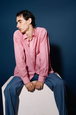 Yakışıklı adam modern moda sergiliyor. Kendine güveni gevşemiş ve şık bir kıyafet giyiyor..