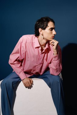 Yakışıklı bir adam oturmuş, derin düşüncelere dalmışken eşsiz moda anlayışını sergiliyor..