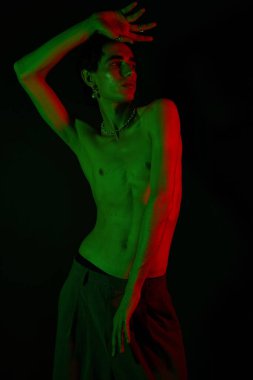 Tarz sahibi bir adam canlı yeşil ve kırmızı ışıklarda durarak dengesiz bir hava yaratıyor..