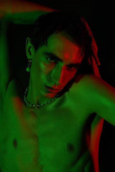 Handsome man showcases his unique fashion sense with striking lighting and a confident posture.