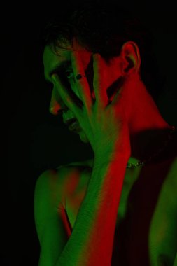 Yakışıklı adam tarzını yeşil ve kırmızı ışıkların altında sergiliyor..