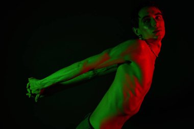 Yakışıklı, modaya uygun bir adam çarpıcı renkli bir ışıkla tarzını sergiliyor..