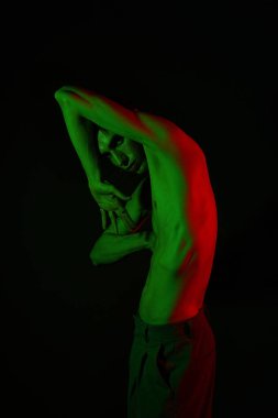 Yakışıklı bir adam canlı renkli pozlar veriyor, sanatsal ve stil ifade ediyor..