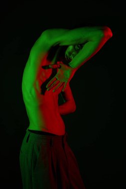 Yakışıklı adam, yaratıcı bir sanat ortamında büyüleyici renklerle şık pozunu sergiliyor..