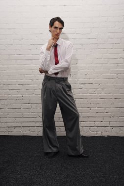 Kendine güvenen bir duruşu olan yakışıklı bir adam şık ve küçük bir mekânda eşsiz bir moda tarzı sergiliyor..