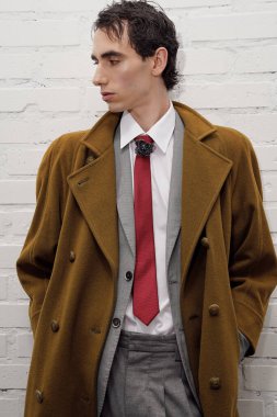 Yakışıklı bir adam modern bir arka plana karşı şık bir şekilde poz veriyor, kendine güveni tam..