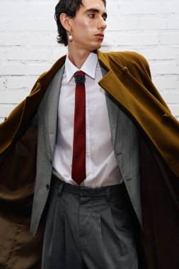 Yakışıklı adam çarpıcı bir kıyafet sergiliyor, şehir ortamında klasik ve çağdaş tarzı harmanlıyor.