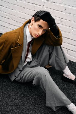 Yakışıklı adam şık giyinmiş yerde rahatlıyor, kendine güveni ve cazibesi var..