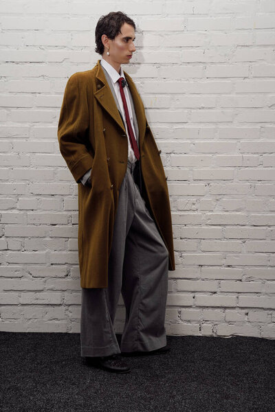 A handsome man showcases his unique fashion sense in a chic urban area at sunset.