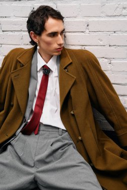 Uzun paltolu ve özel dikim pantolonlu şık bir adam şehirde karizma yayar..