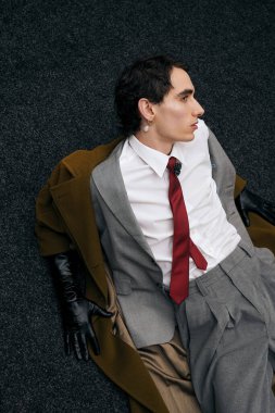 Şık bir adam lüks bir yüzeyde rahatlar, modern modaya güveni tamdır..