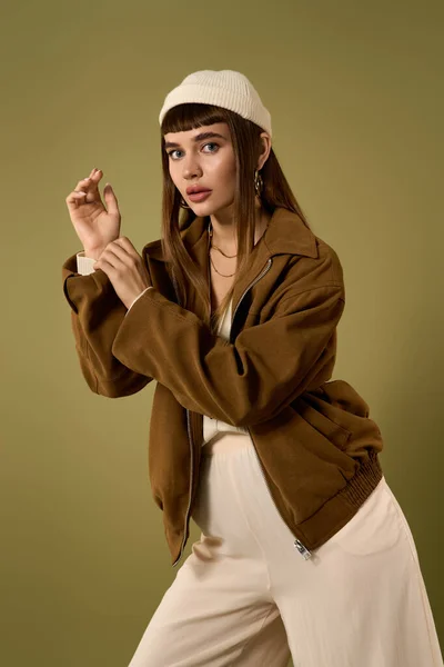 Уверенная в себе молодая женщина демонстрирует свой стиль в шикарной куртке и стильных аксессуарах. — стоковое фото