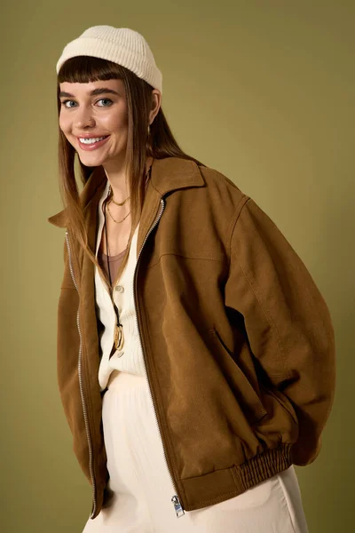 Молода, красива жінка в шикарному вбранні випромінює радість, впевнено позуючи в приміщенні. — стокове фото