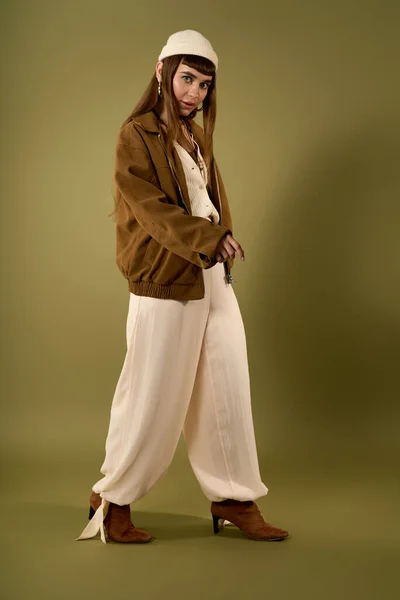 Jovem mulher fica confiante na roupa da moda, irradiando estilo e charme em cores suaves. — Fotografia de Stock